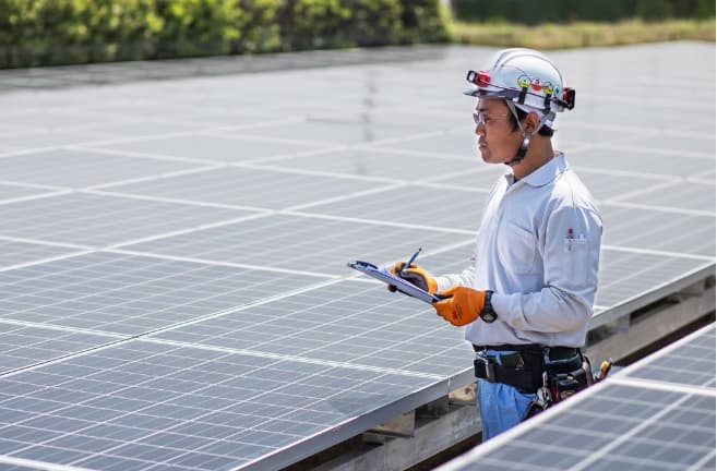 太陽光発電設備を点検するスタッフ